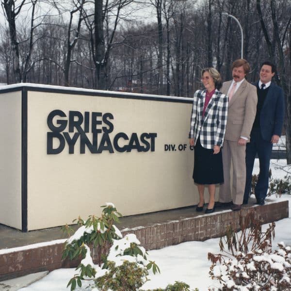 Employees in front of the Gries Dynacast sign